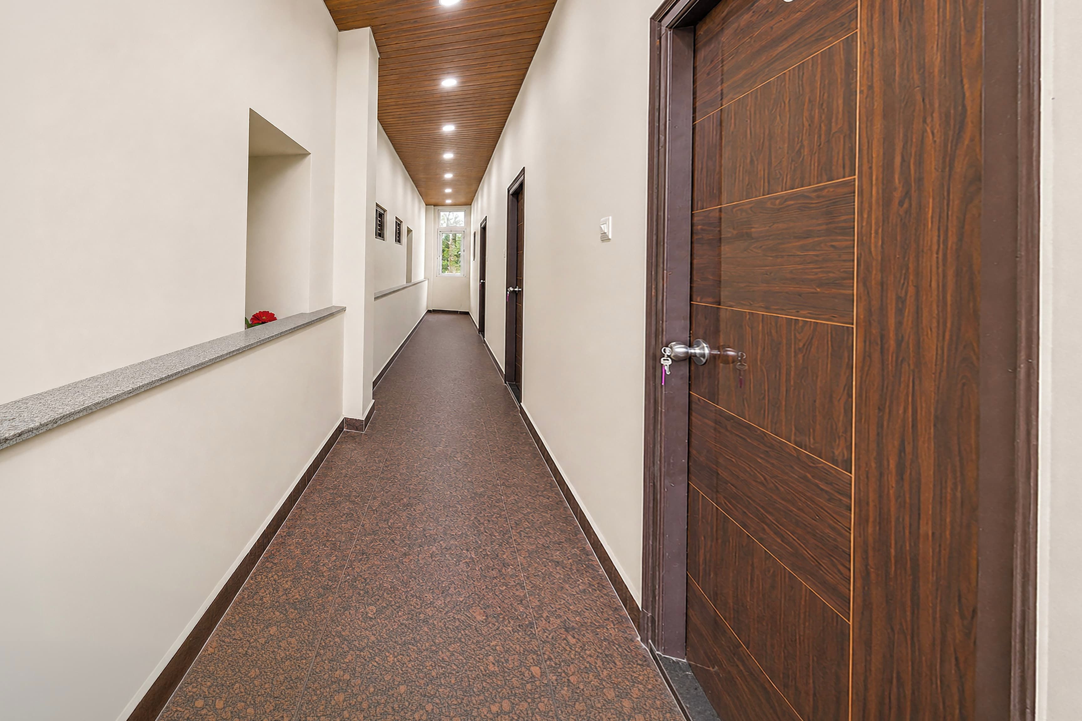 A long, narrow hallway with a wooden ceiling and a carpeted floor.