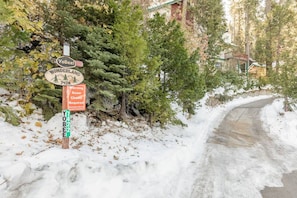 A snow-covered road with a sign indicating Wonderland 7428 and a warning for snow chains. - Inside Yosemite Park- Scenic Cascade (Yosemite National Park)