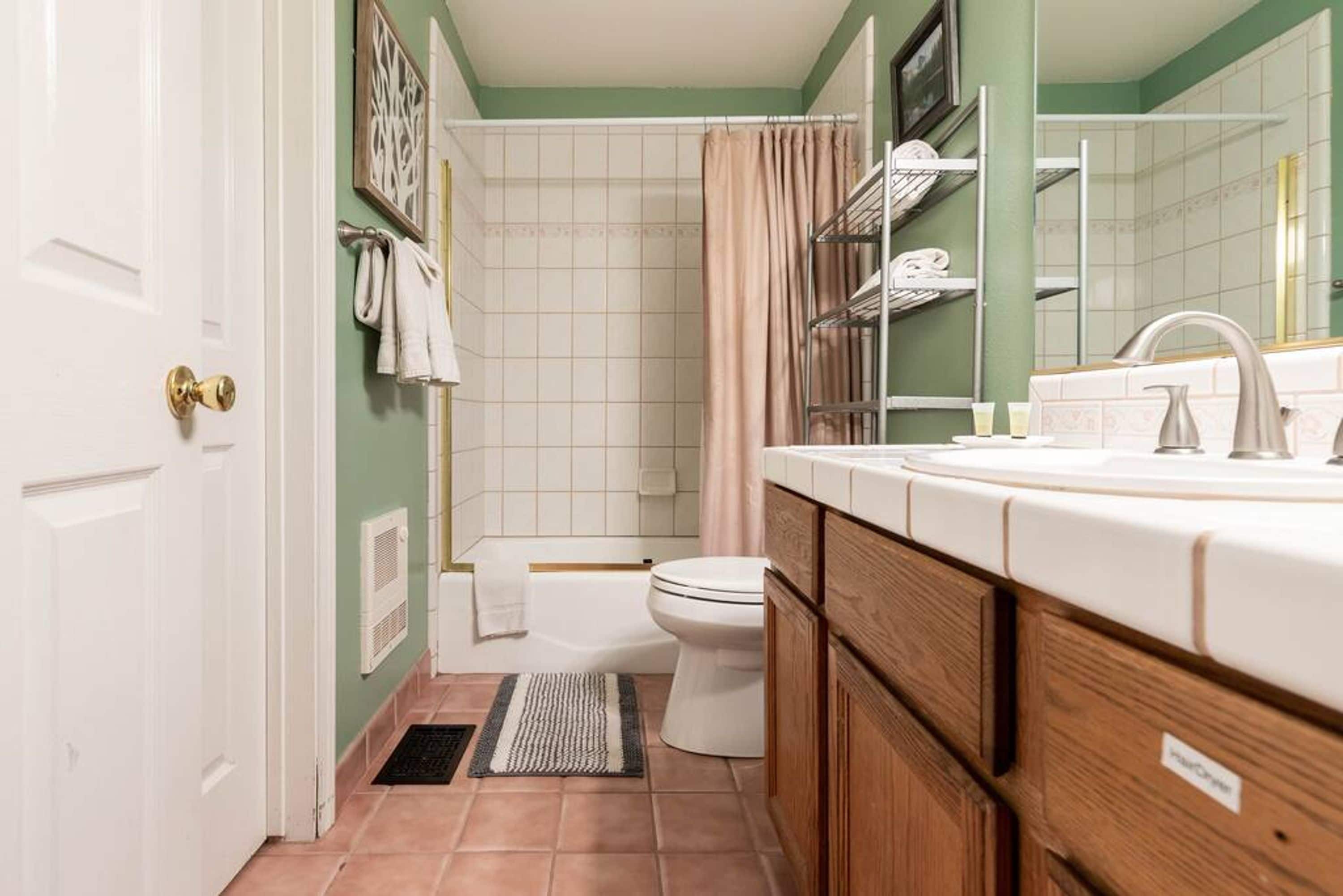 A bathroom with a toilet, sink, and shower area.
