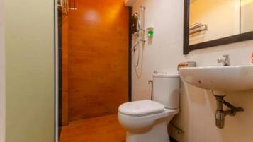 Un baño pequeño con inodoro, lavamanos y ducha.