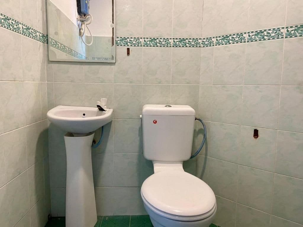 Un baño con inodoro y lavamanos pedestal.