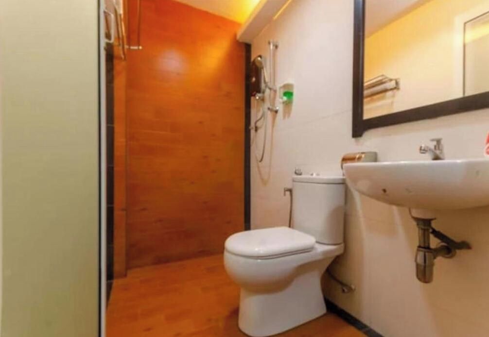 Un baño pequeño con inodoro, lavamanos y ducha.