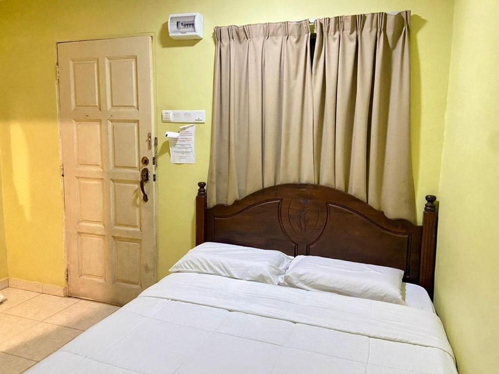 Una habitación con cama, puerta y cortina.