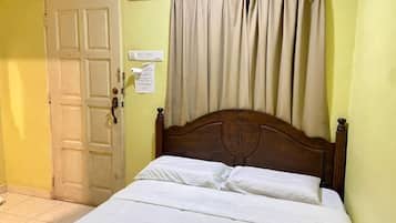 Una habitación con cama, puerta y cortina.