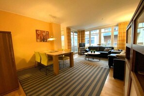Ein Wohnzimmer mit einer Couch, einem Couchtisch und einem Essbereich mit Tisch und Stühlen.
