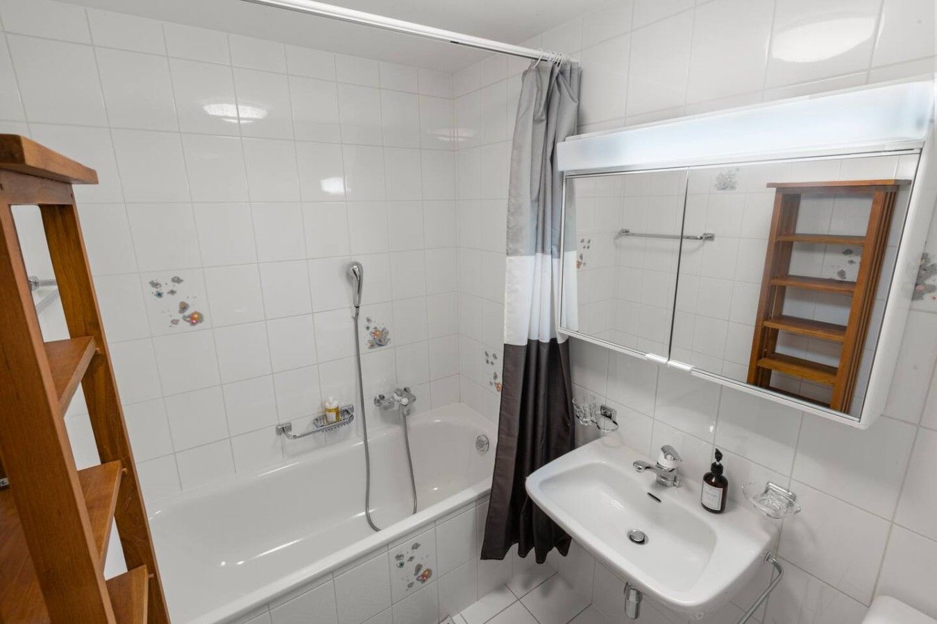 Une salle de bain avec une baignoire, un lavabo, un miroir et une douche.