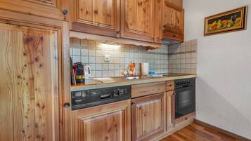 A kitchen with wooden cabinets, a dishwasher, an oven, and a tiled backsplash.