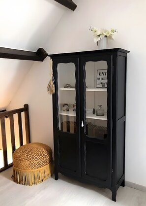 A black cabinet with glass doors, a white vase with flowers, and a wooden chair with a patterned cushion. - Holiday Home 'Le Perroudier' with Panoramic View of the Dordogne Valley (Vitrac)
