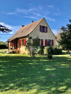 A two-story house with a sloped roof and red shutters, surrounded by a well-maintained lawn and a small garden. - Holiday Home 'Le Perroudier' with Panoramic View of the Dordogne Valley (Vitrac)