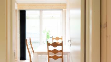 A room with a wooden floor, a white table, and two chairs.