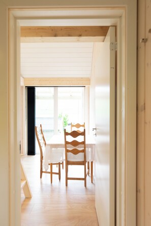 A room with a wooden floor, a white table, and two chairs.