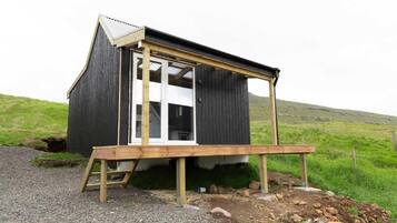 A small wooden structure with a slanted roof and a single visible window.