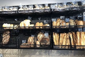 Une vitrine de boulangerie présentant différents types de pain et de viennoiseries.