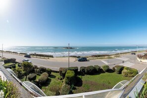 A coastal road with vehicles, a pedestrian crossing, and a clear view of the ocean. - Beautiful Studio for 4 people with 180° sea view by Groom* (Ploemeur)
