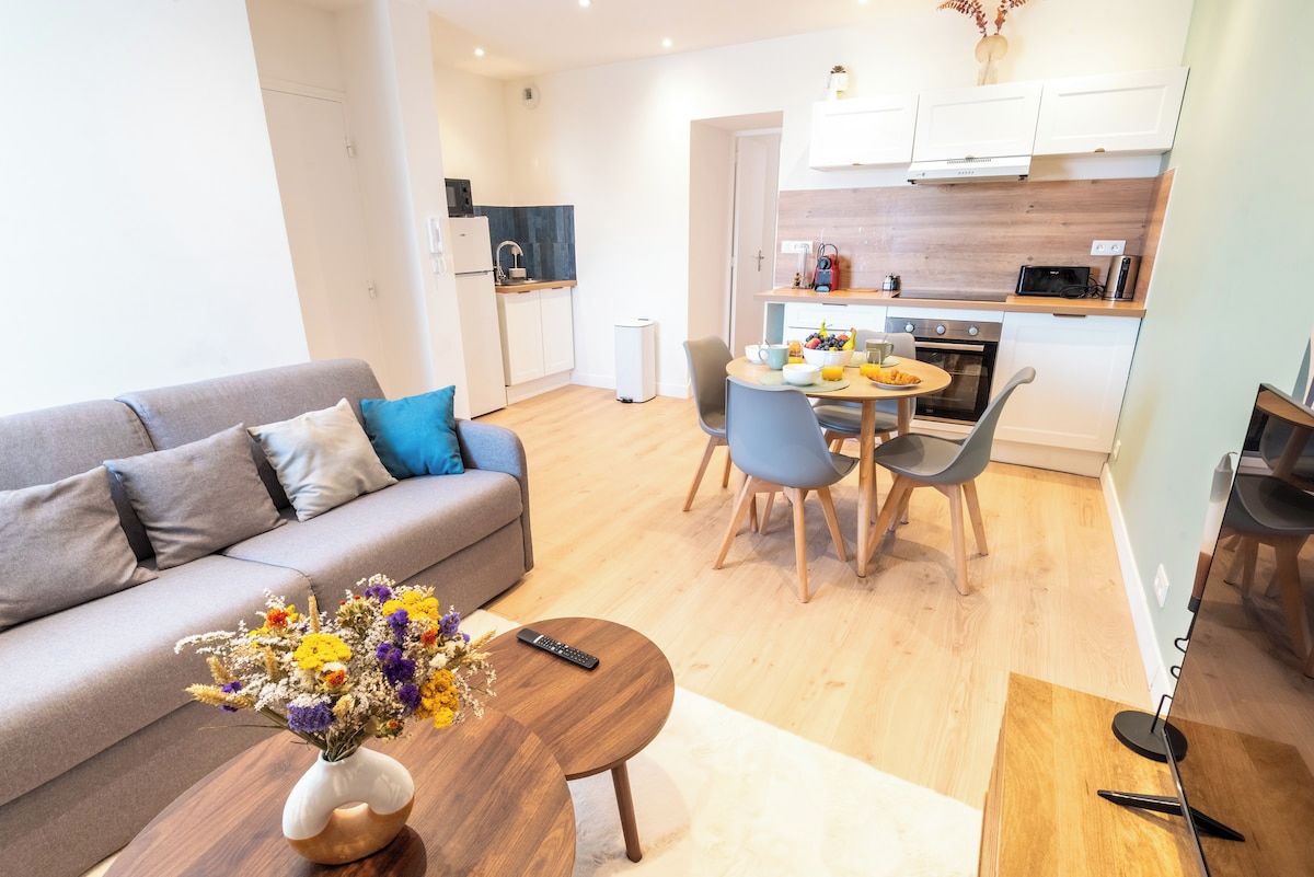 A modern apartment with a living area, a dining table, and a kitchenette.