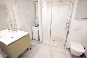 Ein modernes Badezimmer mit Waschbecken, Toilette und einer Duschkabine.