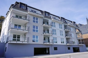 A multi-story residential building with balconies, windows, and a garage entrance. - Holiday apartment with 1 bedroom (Cochem)