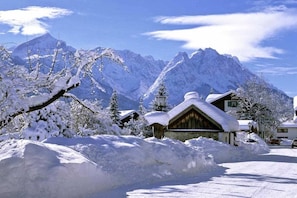 A snow-covered mountain village with traditional wooden houses and a clear sky. - Wank in the Grasegger holiday home (Garmisch-Partenkirchen)