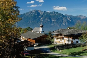 A mountain village with traditional architecture, a church, and a clear view of the mountains. - Wank in the Grasegger holiday home (Garmisch-Partenkirchen)