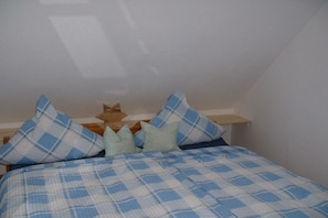 Ein Schlafzimmer mit einem Bett, Kissen und einem Holzkopfstück.