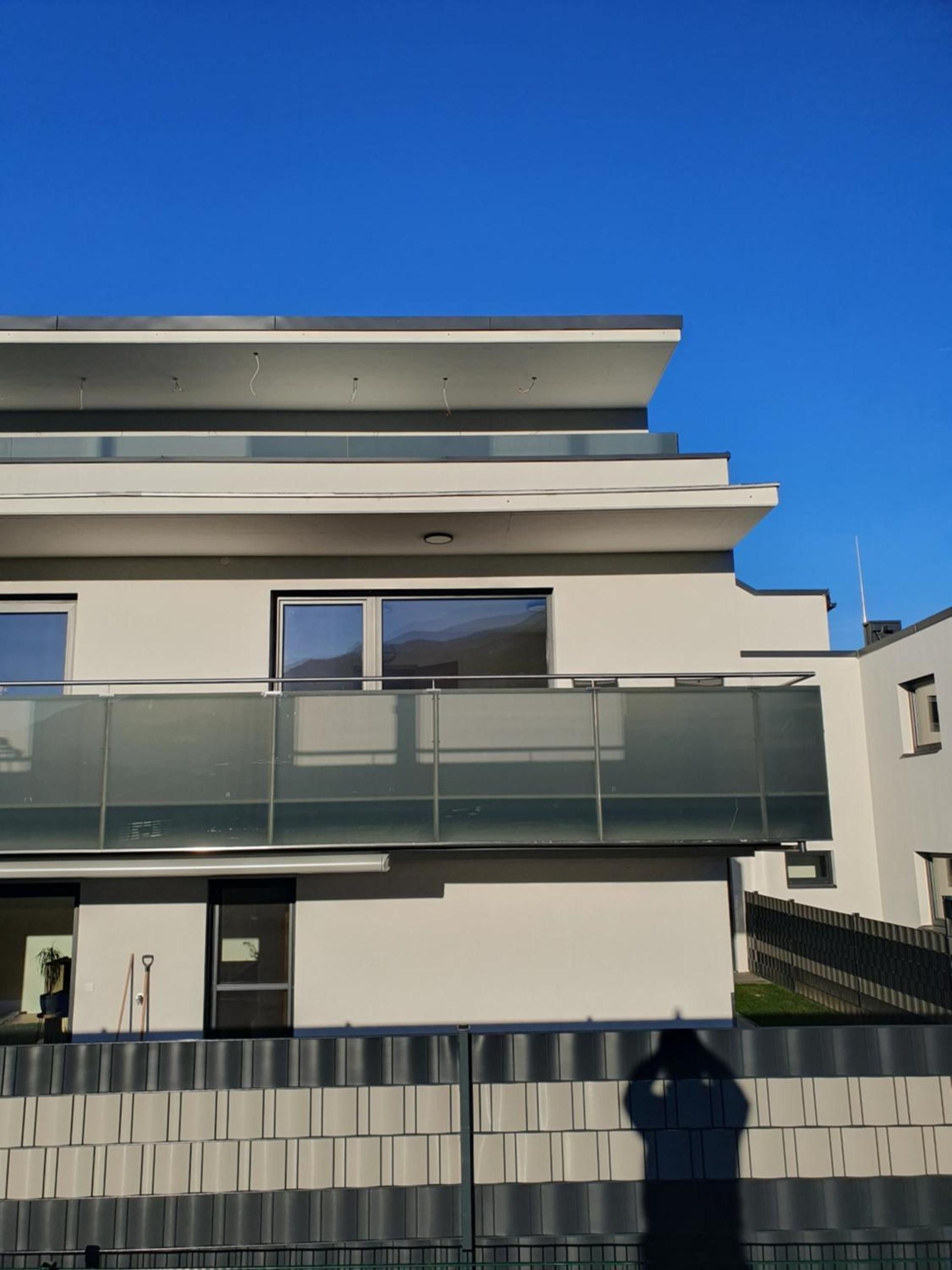 A modern multi-story building with large windows and a flat roof.