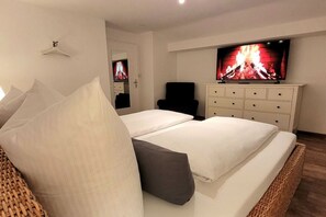 A hotel room with a bed, a television, a dresser, and a chair. - Holiday home in Grainau with swimming pool (Grainau)