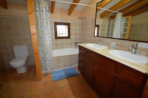 A bathroom with two sinks, a toilet, a shower, and a window with bars. - Finca Estilo Mallorquín Cerca del mar (Alcúdia)