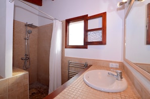 A bathroom with a shower, a sink, a towel rack, and a window with a wooden frame. - Nueva Encantadora Finca con Piscina (Selva)