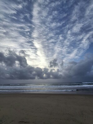 Une plage avec une vaste étendue de sable et une vue sur l’océan.