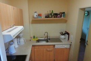 A compact kitchen with a dishwasher, a coffee maker, and a sink. - Holiday apartment with 2 bedrooms (Schillig)