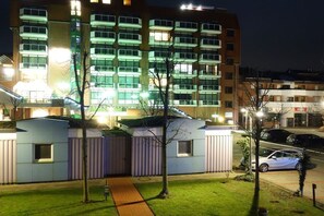 A multi-story hotel with a modern design, featuring balconies and a well-lit facade. - Holiday apartment with 2 bedrooms (Schillig)