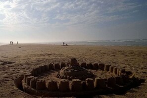 A sandy beach with a circular sand structure in the foreground. - Holiday apartment with 2 bedrooms (Ste. Honorine des Pertes)