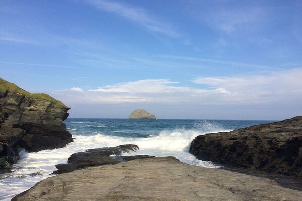 A coastal landscape with rocky terrain and a view of the sea.
