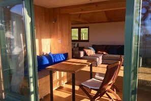 Un espacio de sala acogedor con un banco de madera, un sofá y una mesa.