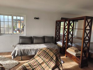 A bedroom with a bed, a wooden bench, a window, and a view of the outside. - Vrbo Property (Cartaxo)