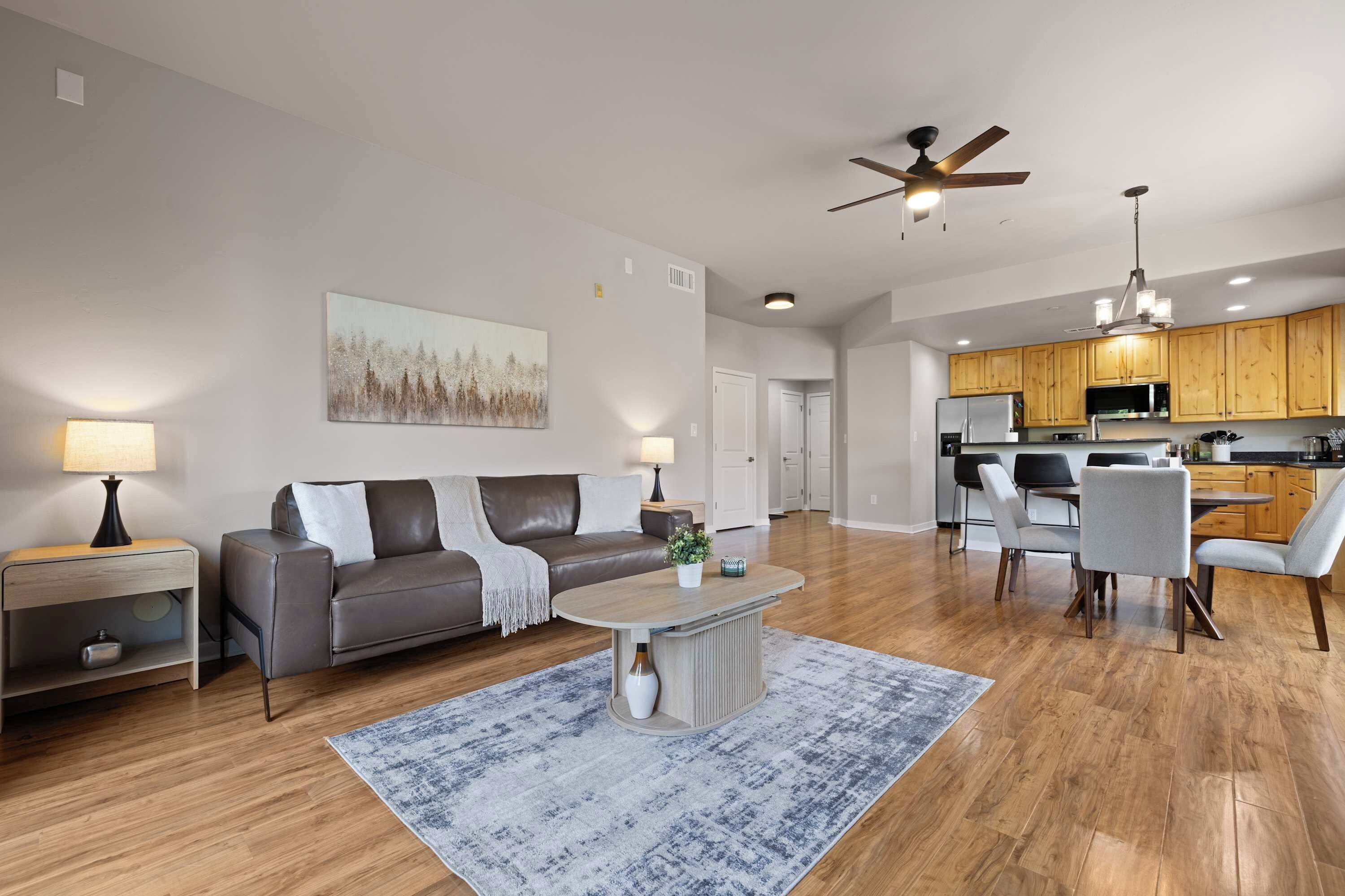 A modern living room with a sofa, coffee table, and a painting on the wall.