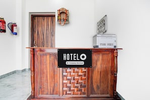 A reception desk with a sign indicating it's a company-serviced hotel. - Hotel College And Institute Technology (Jalsu)