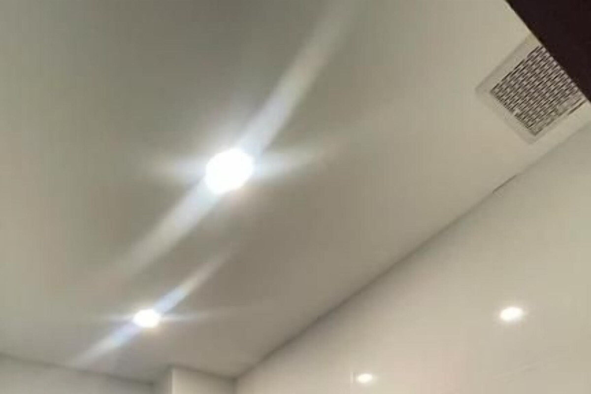 Un baño moderno con ducha de vidrio, inodoro y lavamanos.