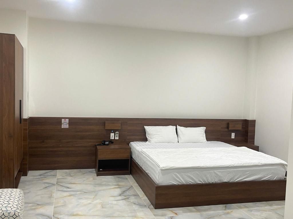 A bedroom with a bed, nightstand, and wardrobe.