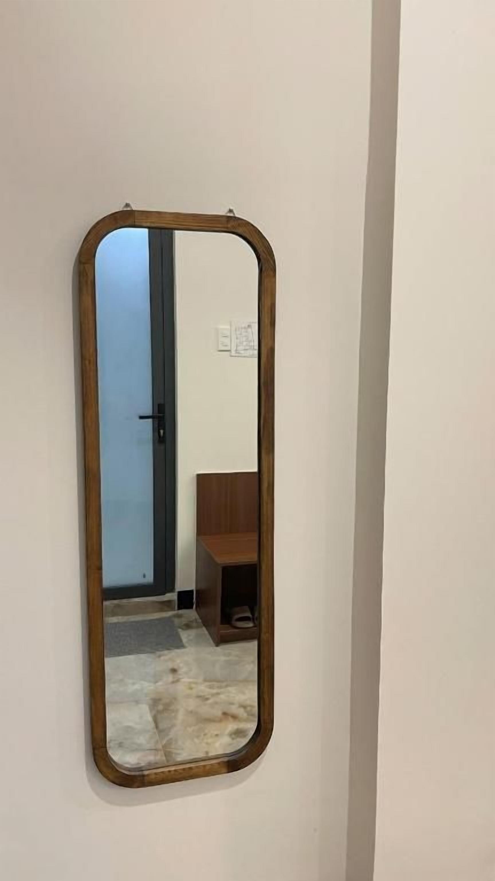 A mirror with a wooden frame on a wall.