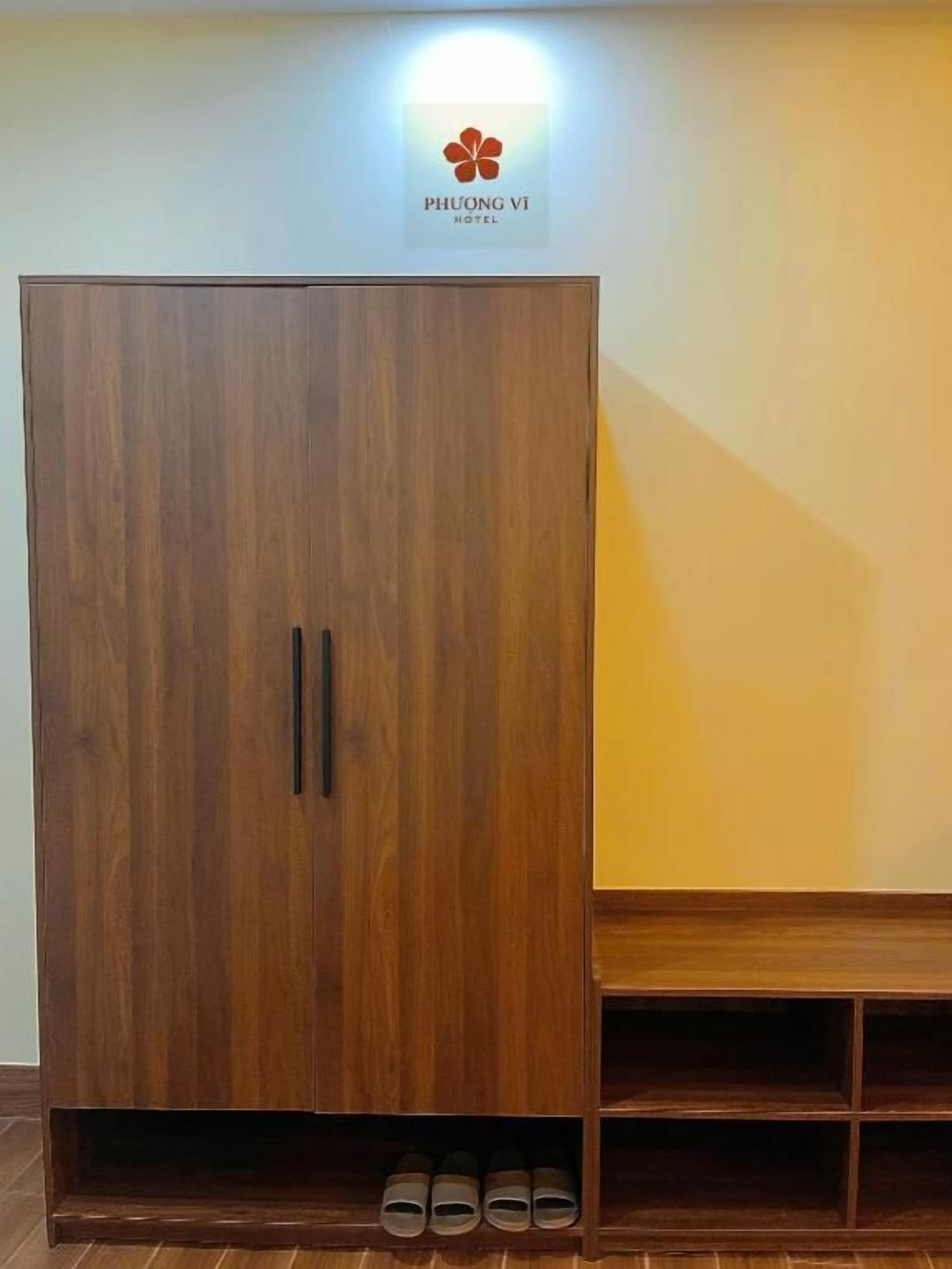 A wardrobe with a logo above it, a bench, and a shoe rack below.