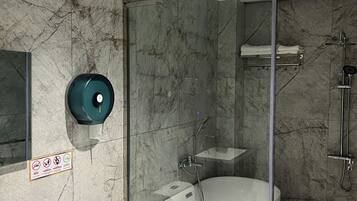 A modern bathroom with a glass-enclosed shower, a freestanding bathtub, and a toilet.
