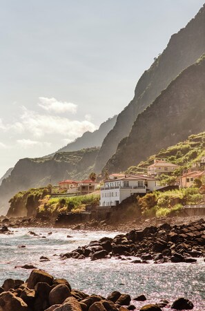 A coastal village with buildings on a hillside overlooking the sea. - Domingos Apartment (São Vicente)