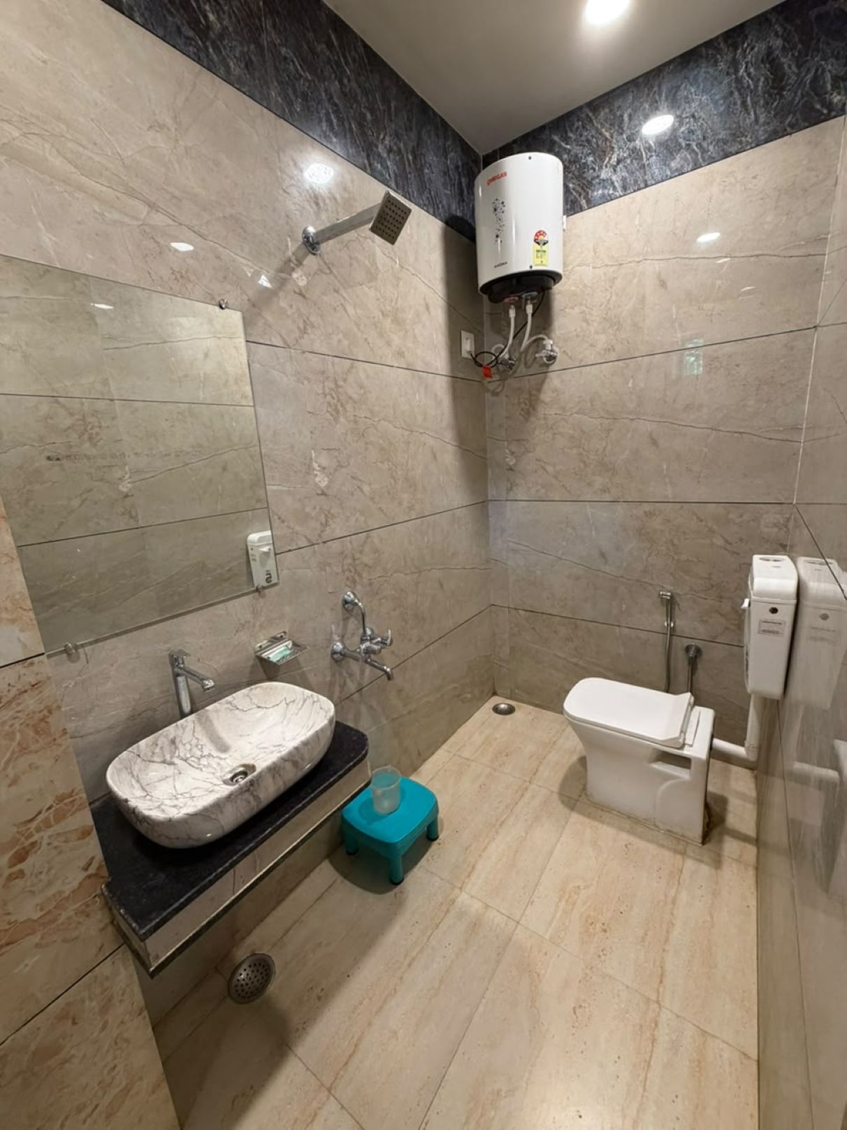 A modern bathroom with a marble sink, a toilet, and a wall-mounted air conditioning unit.