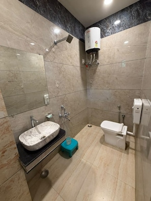 A modern bathroom with a marble sink, a toilet, and a wall-mounted air conditioning unit.