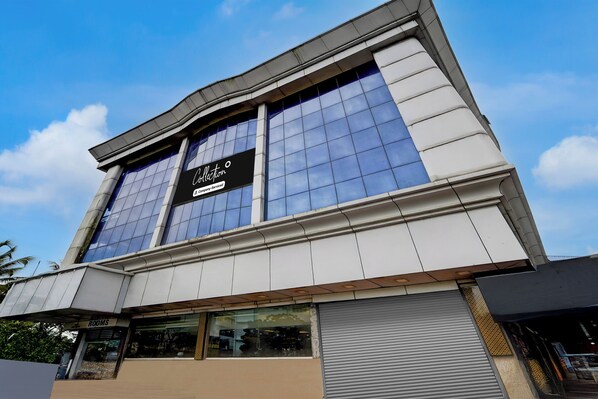 A modern building with large windows and a sign indicating it is a company-serviced location. - Collection Formerly Malabar Residency (Kanayannur)