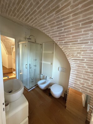 A bathroom with a glass-enclosed shower, a bidet, and a sink. - Historic residence in the city center (Perugia)