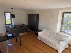 A modern kitchen with a gas stove, a black cabinet, and a window with a view of buildings. - Historic residence in the city center (Perugia)