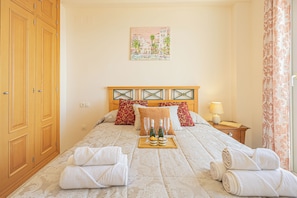 Habitació d'hotel amb un llit, una tauleta de nit, un quadre i un armari.