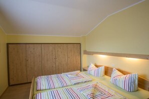 Ein Zimmer mit einem Bett, Kissen, einem Holzschrank und einem Nachttisch.